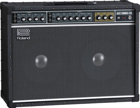 The image shows a Roland Jazz Chorus-120 guitar amplifier with a black tolex exterior, metal corner protectors, and a large grille covering dual speakers. The control panel features two channels, multiple tone and volume knobs, and built-in effects like chorus and reverb. The amp is known for its clean tone, 120-watt power, and durable, professional-grade construction favored by jazz and clean guitar players.