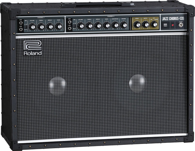 The image shows a Roland Jazz Chorus-120 guitar amplifier with a black tolex exterior, metal corner protectors, and a large grille covering dual speakers. The control panel features two channels, multiple tone and volume knobs, and built-in effects like chorus and reverb. The amp is known for its clean tone, 120-watt power, and durable, professional-grade construction favored by jazz and clean guitar players.