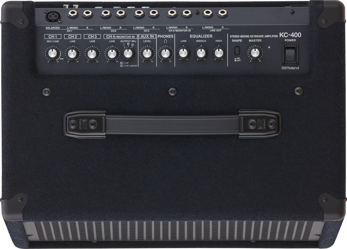 The image shows a Roland KC-400 Stereo Mixing Keyboard Amplifier, designed for electronic keyboards and digital pianos. It features multiple input channels with individual volume controls, mic/line and stereo inputs, auxiliary input, headphone output, 3-band EQ, master volume, power switch, and various output jacks. The portable design includes a handle and protective corners, making it ideal for live performance, practice, or recording.