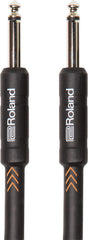 The image shows a Roland audio cable with two 1/4-inch TS (Tip-Sleeve) connectors, used for connecting electric guitars, basses, keyboards, and other instruments to amplifiers or audio gear. It features black Roland-branded housings, chrome-plated plugs, and a black cable with orange chevron markings. This durable, industry-standard instrument cable is essential for transmitting audio signals in music setups.