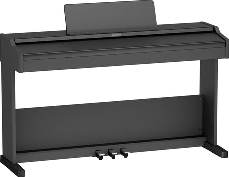 The image shows a Roland digital piano with a charcoal gray console-style cabinet. It features a full-size adjustable music rest, three pedals, and weighted keys for an acoustic feel. The sleek, minimalist design includes a sturdy built-in stand. This modern electronic instrument is ideal for home use and practice, offering volume control, headphone output, and the realistic sound and touch Roland is known for.