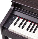 The image shows a digital piano with a traditional white and black keyboard housed in a dark wood grain cabinet, giving it an elegant, furniture-like appearance. It features a control panel with buttons on the left side, including power and volume controls. The keys appear weighted or semi-weighted, and the design suggests it’s a home digital piano rather than a portable keyboard.
