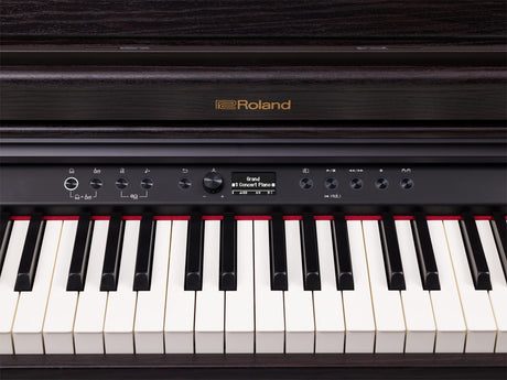 The image shows a Roland digital piano with the "Roland" logo in gold. It features a traditional 88-key layout, a control panel with rotary knobs, buttons, a digital display reading "Grand" and "Concert Piano," transport controls, and tempo functions. The instrument has a sleek black finish and a modern design, indicating a high-end model suited for home and professional use.