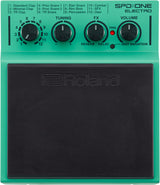 The image shows a Roland SPD::ONE ELECTRO electronic percussion pad with a green/teal housing and large black rubber playing surface. It features a 12-position selector knob for sound presets, three control knobs for TUNING, FX, and VOLUME, plus red TRIG and INST VARIATION buttons. Compact and portable, it’s designed for drummers to trigger electronic sounds via sticks or hands.
