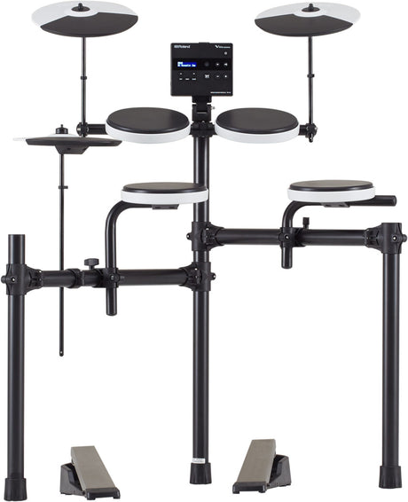 The image shows a Roland V-Drums electronic drum kit, featuring multiple rubber drum pads with white rims, two cymbal pads on adjustable stands, a central module with LCD display, and a black tubular rack. It includes two foot pedals and displays Roland branding. The compact, all-black design is ideal for home practice and recording, offering adjustable mounting, volume control, and diverse drum sounds in a space-saving setup.