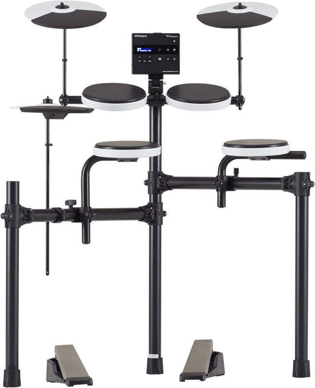 The image shows a Roland V-Drums electronic drum kit, featuring multiple rubber drum pads with white rims, two cymbal pads on adjustable stands, a central module with LCD display, and a black tubular rack. It includes two foot pedals and displays Roland branding. The compact, all-black design is ideal for home practice and recording, offering adjustable mounting, volume control, and diverse drum sounds in a space-saving setup.