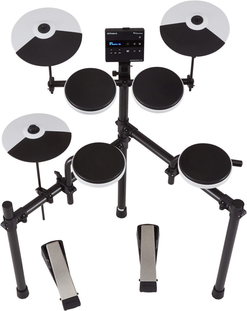 The image shows a complete Roland V-Drums electronic drum kit featuring a central drum module with display, multiple black and silver drum and cymbal pads, cymbal pads on adjustable arms, tom and snare pads, a metal rack system, and foot pedals for bass drum and hi-hat. This modern kit enables silent practice with headphones or amplified play, offering various sounds, metronome, and recording functions for home, studio, or live use.