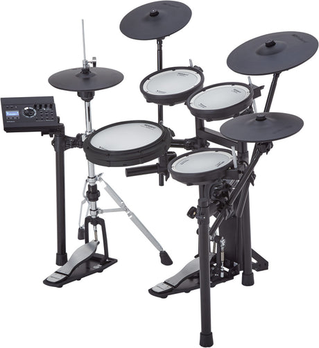 The image shows an electronic drum kit with multiple white mesh drum pads, several black electronic cymbals, a kick drum pedal, and hi-hat pedal. It includes a black sound module for volume and sound settings, mounted on an adjustable metal rack with clamps and tripod legs. This digital kit is compact, quiet for headphone use, versatile for sounds, and suitable for practice, performance, and recording.