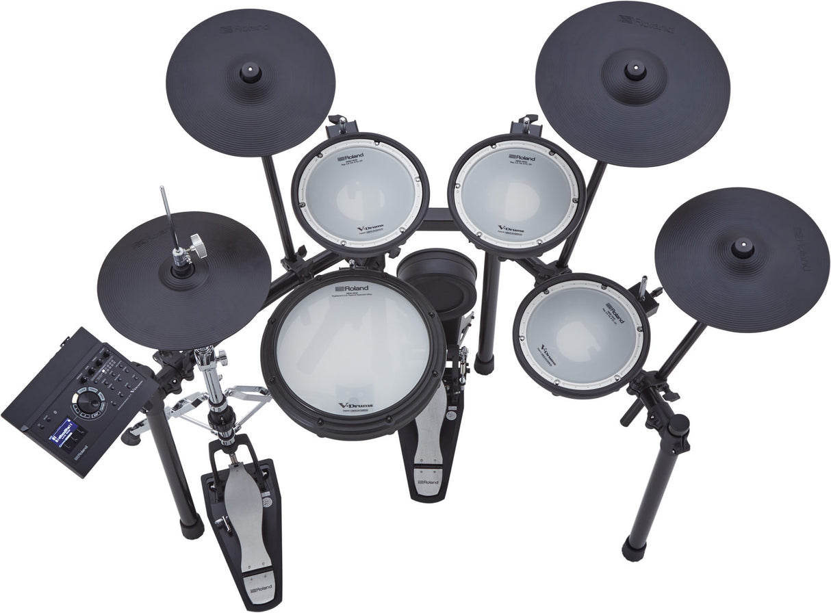 The image shows a Roland electronic drum set featuring multiple white mesh drum pads, black electronic cymbal pads, a kick drum pad, hi-hat pedal, and a drum module on the left. This modern kit offers realistic play with mesh heads and electronic controls for headphone use, recording, and a variety of sounds. Roland is a trusted brand known for quality electronic drums and instruments.