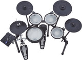 The image shows a Roland electronic drum set featuring multiple white mesh drum pads, black electronic cymbal pads, a kick drum pad, hi-hat pedal, and a drum module on the left. This modern kit offers realistic play with mesh heads and electronic controls for headphone use, recording, and a variety of sounds. Roland is a trusted brand known for quality electronic drums and instruments.