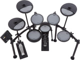The image shows a Roland V-Drums electronic drum kit with multiple mesh-head pads, dual-zone crash and ride cymbals, a hi-hat pedal, bass drum pedal, and a black drum module. The kit features a sturdy black rack system and realistic mesh heads for natural feel. Designed for practice, recording, or live use, it offers volume control, diverse sounds, and space-saving benefits typical of Roland’s high-quality V-Drums series.