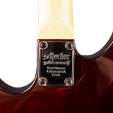 Close-up of the back of a Schecter guitar neck joint with brand name and location details.