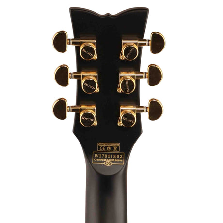 The back of a black Schecter Solo II Custom Electric Guitar headstock. It has gold tuning pegs. 