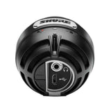 The image shows the bottom/base of a Shure dynamic microphone with the brand name on top. The connection panel includes a USB port and a standard audio output jack, suggesting a USB/analog hybrid model. The microphone features a black, durable design typical of Shure’s professional-grade microphones, known for use in recording, live performances, and broadcasting.