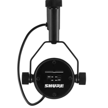 The image shows a Shure microphone shock mount with a black metal circular hub, elastic suspension cords, and a threaded post for stands. It features two side knobs for adjustments. This professional audio accessory isolates microphones from vibrations and handling noise, commonly used in studios and live settings to improve sound quality by reducing mechanical disturbances.