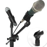 The image shows various microphone accessories including two microphones—one handheld dynamic with a silver grille and another with a teal body—a black adjustable multi-arm microphone stand, several black microphone clips for securing mics to the stand, and connecting audio cables. It highlights a multi-mic setup ideal for studios, live performances, or podcasting.