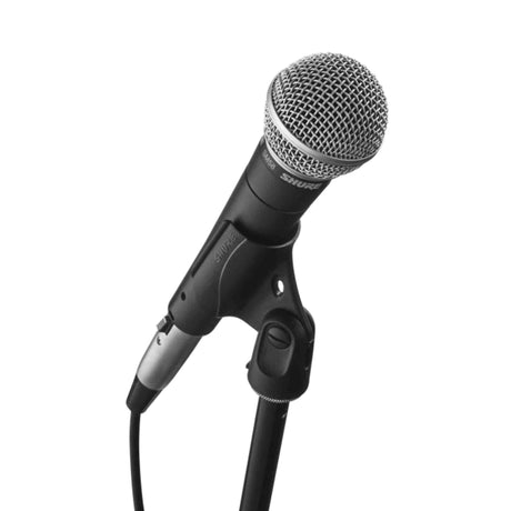 The image shows a Shure SM58 dynamic microphone with a black body, silver spherical mesh grille, attached mic stand clip, and an XLR cable connection at the base. Known for durability and excellent sound quality, it is widely used by vocalists and audio professionals in live performances and studio recordings.