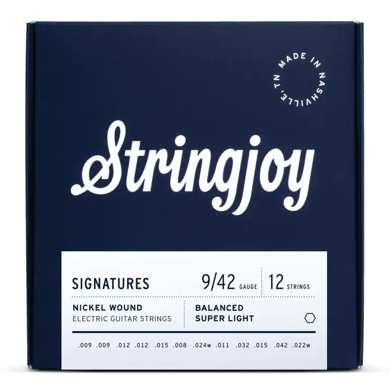 The image shows a package of Stringjoy Signatures series 12-string electric guitar strings, gauge 9/42, nickel wound, labeled "Balanced Super Light." The navy blue box features white elegant script typography, a "Made in Nashville" badge, and a minimalist design. String gauges printed include .009, .012, .015, .008, .024w, .011, .032, .042, and .022w, indicating a premium set for 12-string guitars.