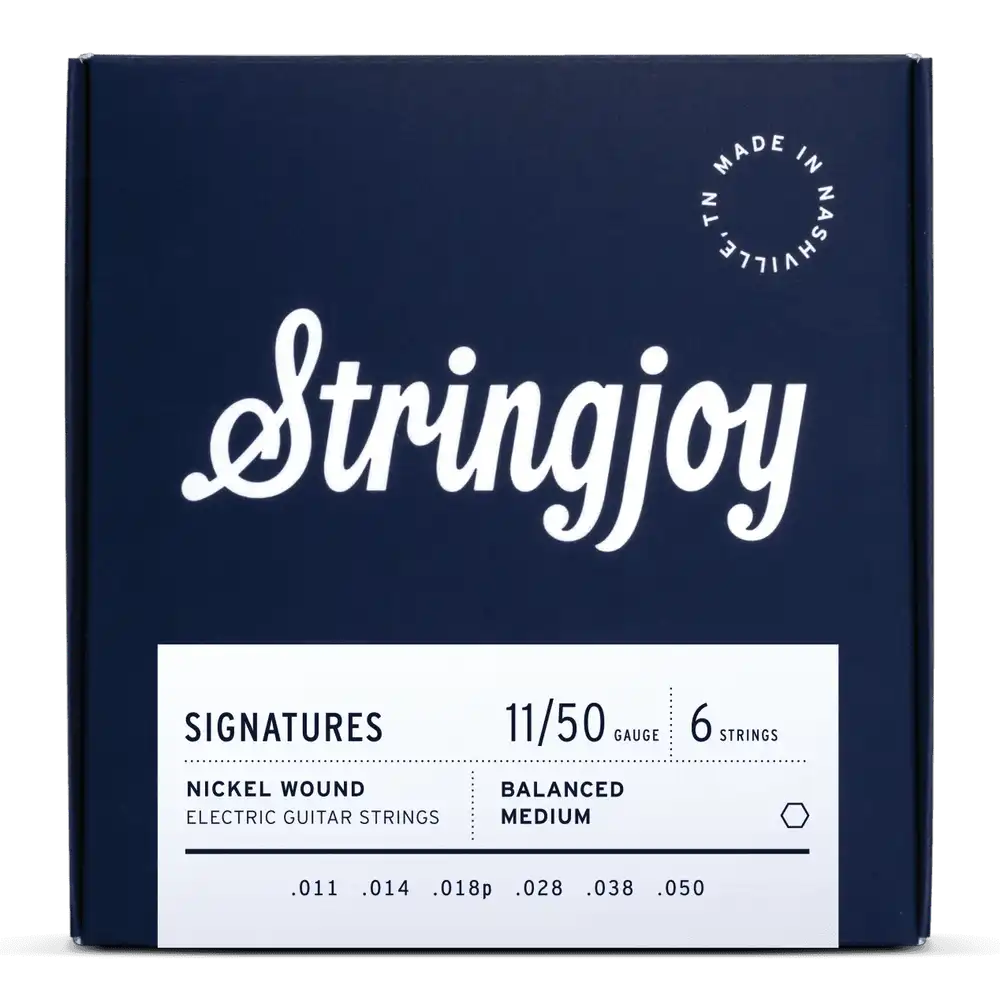 The image shows a package of Stringjoy Signatures nickel wound electric guitar strings. It is a 6-string set with medium gauge 11-50 (.011, .014, .018p, .028, .038, .050) and balanced medium tension. The navy blue box features white text and "Made in Nashville, TN" in the upper right corner. This premium set offers even tension and tone, popular among players seeking quality, American-made strings.