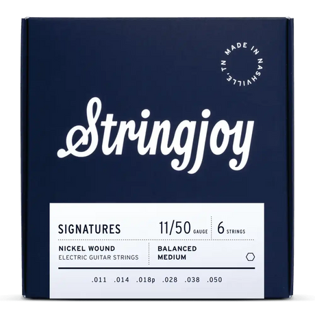 The image shows a package of Stringjoy Signatures nickel wound electric guitar strings. It is a 6-string set with medium gauge 11-50 (.011, .014, .018p, .028, .038, .050) and balanced medium tension. The navy blue box features white text and "Made in Nashville, TN" in the upper right corner. This premium set offers even tension and tone, popular among players seeking quality, American-made strings.