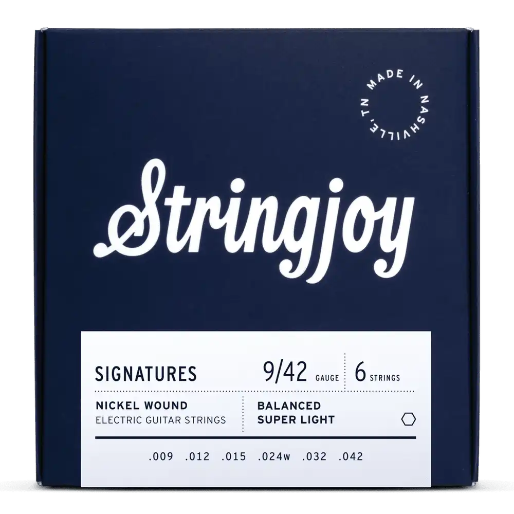 The image shows a package of Stringjoy Signatures series electric guitar strings. It’s a 6-string set with super light 9-42 gauge nickel wound strings featuring balanced tension design. The navy blue packaging has white text and a "Made in Nashville, TN" logo, indicating American-made quality. This set offers consistent tension across strings, favored by lead guitarists for easier bends.