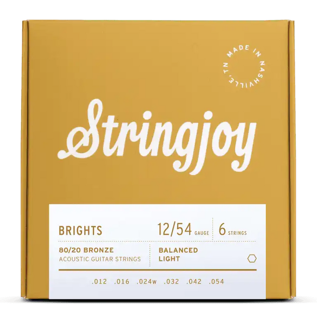 The image shows a package of Stringjoy "Brights" acoustic guitar strings. The light gauge 12-54 set is made of 80/20 bronze with six strings (.012 to .054). The packaging features a golden-yellow box with white script logo, a white info panel, and a "Made in Nashville" badge, highlighting a premium, professional presentation.
