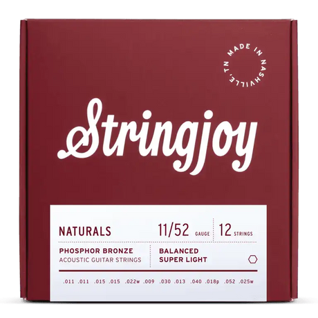 The image shows a burgundy box of Stringjoy acoustic guitar strings, a 12-string set made in Nashville, TN. These phosphor bronze strings have a balanced super light gauge of 11/52, with individual string sizes listed on the package. The design features clean white lettering and a circular "Made in Nashville TN" logo, part of the "NATURALS" product line known for warm tone and durability.