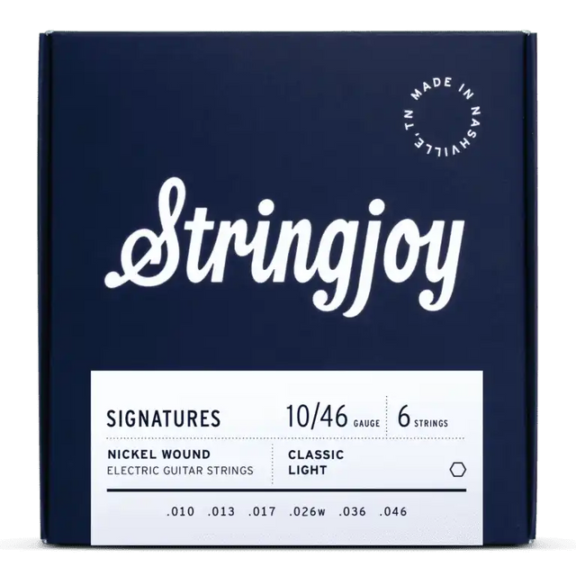 The image shows a dark blue box of Stringjoy "SIGNATURES" electric guitar strings with white script lettering. It features 6 nickel-wound strings, Classic Light gauge 10-46 (.010, .013, .017, .026w, .036, .046), made in Nashville, TN. The packaging is sleek and professional, indicating a premium set that balances playability and tone for electric guitars.