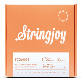 The image shows a package of Stringjoy Foxwoods coated phosphor bronze acoustic guitar strings for 12-string guitars. The balanced super light set is gauge 11/52. The orange/coral box features the Stringjoy logo, technical specs on a white label, a "Made in Nashville" badge, and lists individual string gauges. The packaging suggests a premium, corrosion-resistant string set.