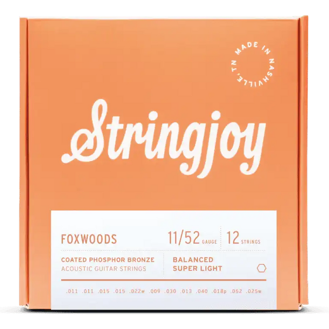 The image shows a package of Stringjoy Foxwoods coated phosphor bronze acoustic guitar strings for 12-string guitars. The balanced super light set is gauge 11/52. The orange/coral box features the Stringjoy logo, technical specs on a white label, a "Made in Nashville" badge, and lists individual string gauges. The packaging suggests a premium, corrosion-resistant string set.
