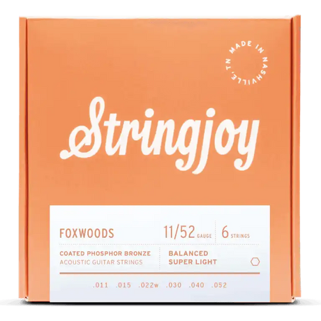 The image shows a package of Stringjoy Foxwoods coated phosphor bronze acoustic guitar strings. The orange/coral box features a script-style logo, a "Made in Nashville" badge, and a white label listing specs. This 6-string set is Balanced Super Light gauge 11-52 (.011, .015, .022w, .030, .040, .052), offering warm tone and corrosion resistance.