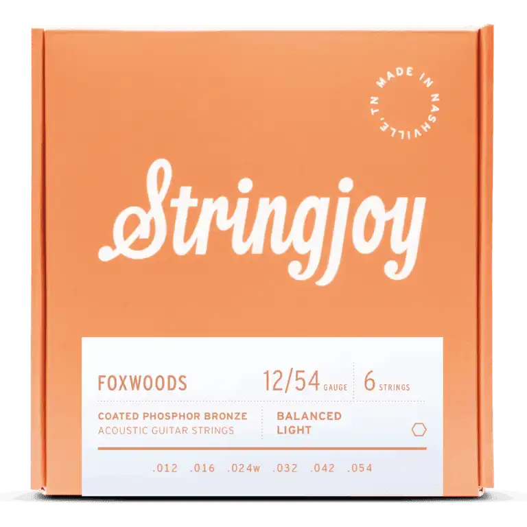 The image shows a package of Stringjoy Foxwoods coated phosphor bronze acoustic guitar strings. It features a 6-string set with 12/54 balanced light gauge (.012, .016, .024w, .032, .042, .054). The orange box has white text, a “Made in Nashville” logo, and a modern, professional design. These strings offer a bright, warm tone with enhanced durability and easier playability.