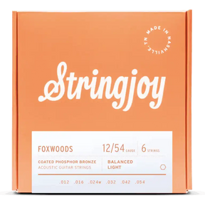 The image shows a package of Stringjoy Foxwoods coated phosphor bronze acoustic guitar strings. It features a 6-string set with 12/54 balanced light gauge (.012, .016, .024w, .032, .042, .054). The orange box has white text, a “Made in Nashville” logo, and a modern, professional design. These strings offer a bright, warm tone with enhanced durability and easier playability.