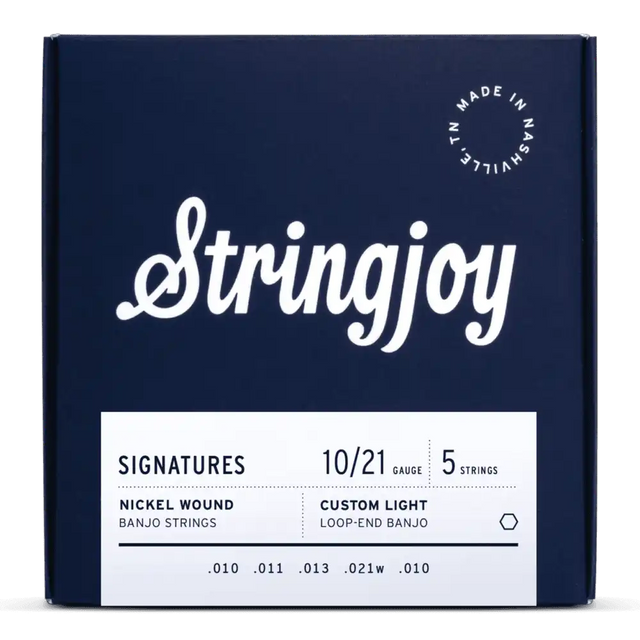 The image shows a package of Stringjoy Signatures Series banjo strings, nickel wound, custom light gauge (10/21), 5-string set for loop-end banjos. The navy blue box features white lettering and a "Made in Nashville" logo. String gauges (.010, .011, .013, .021w, .010) are listed at the bottom. These high-quality, hand-wound strings are made in small batches in Nashville, TN.