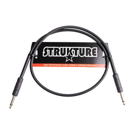 The image shows a STRUKTURE brand high-performance audio cable with 1/4" jack connectors on both ends, designed for musical instruments. The black cable features a lifetime warranty label on its packaging and is likely a short instrument or patch cable used for connecting guitars, basses, keyboards, and audio equipment in live or studio settings.