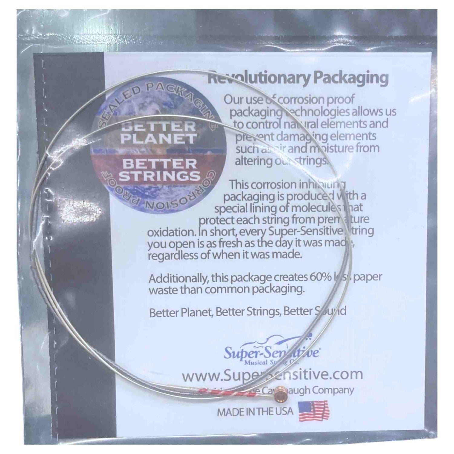 The image shows a single guitar string from Super-Sensitive’s "Better Planet, Better Strings" line, packaged in corrosion-proof, innovative packaging made in the USA. The design protects the string from air and moisture to prevent oxidation, keeps it fresh, and reduces paper waste by 60%. The string features a ball-end and appears wound, reflecting a sustainable, quality-focused approach.