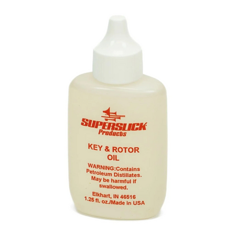 The image shows a small bottle of "Key & Rotor Oil" by Superslick Products, a lubricant for brass and woodwind instruments. It is designed to oil keys, rotors, and moving parts on instruments like trumpets, French horns, trombones, saxophones, and clarinets. The 1.25 fl. oz. squeeze bottle has a dispensing tip for precise application, helping keep instrument mechanisms smooth and preventing sticking or corrosion.