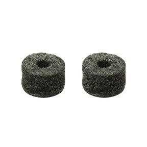 The image shows two small, round, dark cylindrical drum cymbal felts with holes in the center. These felt washers fit over cymbal stand rods, cushioning cymbals from metal contact. They protect cymbals, allow natural movement and resonance, and reduce unwanted noise. The visible dark, fibrous texture is typical of compressed felt, essential for preserving cymbal sound and durability.