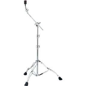 The image shows a chrome cymbal boom stand with a tripod base featuring rubber feet for stability. It has a telescoping main post for height adjustment and an angled boom arm to position cymbals at various angles and distances. Multiple wing nut clamps secure adjustments, and a cymbal holder with a felt washer tops the stand. This stand is used to place cymbals precisely in drum kits without obstructing the drummer.