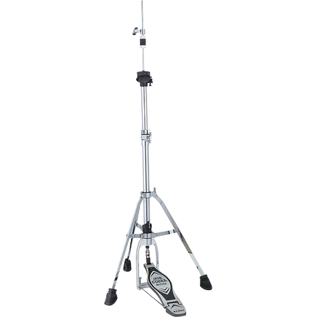 The image shows a professional-grade hi-hat stand with a tall chrome telescoping pole, tripod base with rubber feet, and foot pedal mechanism to open and close two cymbals. It features adjustment clamps along the stand and supports typical hi-hat cymbals (13"-15"). Pressing the pedal brings the cymbals together for the "chick" sound, essential for an acoustic drum kit.