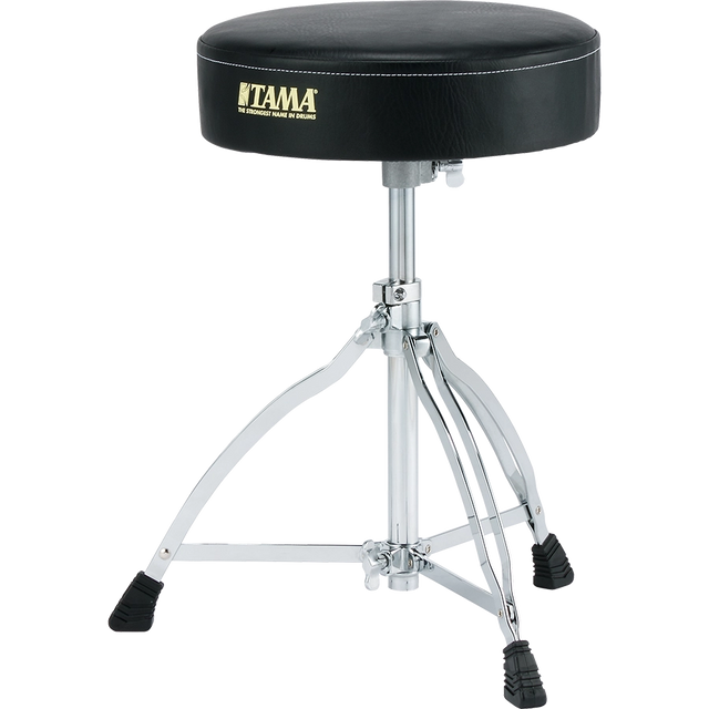 The image shows a Tama drum throne with a round, padded black seat featuring the gold "TAMA" logo and slogan. It has an adjustable chrome center post, a sturdy tripod base with rubber feet, and heavy-duty hardware. This professional drum stool offers comfort, stability, and ergonomic support, making it essential for drummers to maintain good posture and play comfortably.