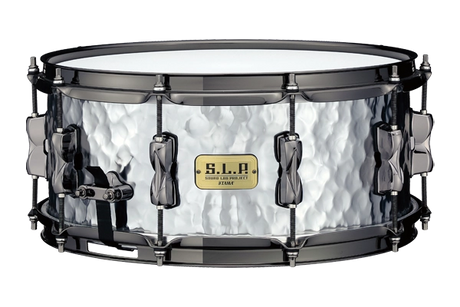 The image shows a TAMA S.L.P. snare drum with a distinctive hammered metal shell and black hardware. It features tension rods around the circumference, a snare throw-off lever, and the TAMA S.L.P. badge. This professional-quality drum, likely made of steel or aluminum, combines a textured finish that enhances both its look and sound, suitable for various musical styles.