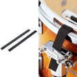 The image shows two black foam or rubber drum dampening strips on the left, and on the right, these strips applied to a drum kit’s heads or hardware to reduce sustain and control overtones. Visible drum hardware is chrome-plated, with an orange/amber drum shell. These muffling strips help drummers achieve a tighter sound and modify tone without permanent changes.