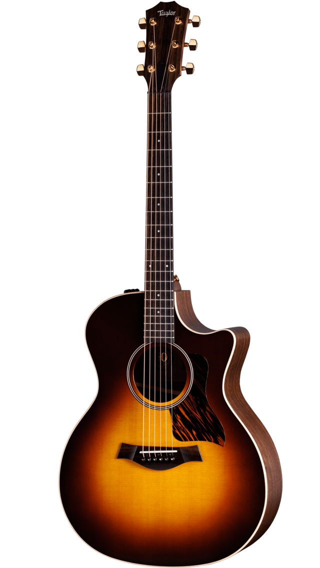 The image shows a Taylor acoustic-electric guitar with a Grand Auditorium cutaway body. It features a sunburst finish, dark wood back and sides, a round soundhole with rosette, tortoiseshell pickguard, and gold tuning machines. The dark fretboard has dot markers, and the cutaway allows easy access to higher frets. This high-end model highlights premium craftsmanship and materials typical of Taylor Guitars.