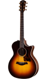 The image shows a Taylor acoustic-electric guitar with a Grand Auditorium cutaway body. It features a sunburst finish, dark wood back and sides, a round soundhole with rosette, tortoiseshell pickguard, and gold tuning machines. The dark fretboard has dot markers, and the cutaway allows easy access to higher frets. This high-end model highlights premium craftsmanship and materials typical of Taylor Guitars.