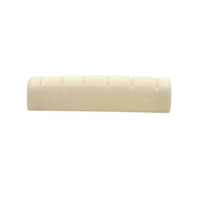 The image shows a guitar nut, a small rectangular piece made of bone or synthetic material, with grooves to hold and space the strings. It sits between the headstock and neck, before the first fret. This nut appears unfinished, needing final fitting and slotting. Guitar nuts are vital for string height, spacing, and playability, and can be made from materials like bone, brass, or graphite, affecting tone and durability.