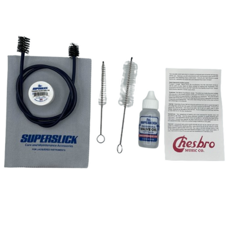 The image shows a brass instrument care and maintenance kit including SuperSlick cleaning products, a flexible cleaning rod with brushes, valve oil, specialized cleaning brushes, and an instruction manual from Presbro Music Co. The kit helps brass players maintain smooth valve action, prevent corrosion, and extend instrument life through regular cleaning and lubrication.