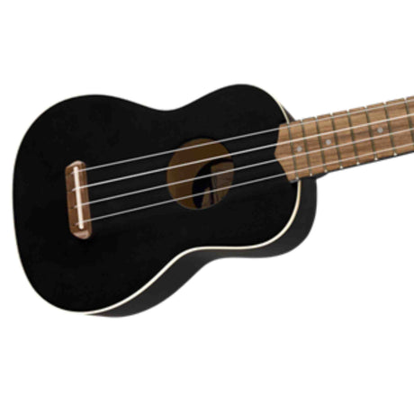 The image shows a black acoustic ukulele with a glossy finish and light binding. It has a natural wood-colored neck and fretboard with dot markers, four nylon strings, and a traditional sound hole. The ukulele features a bone or plastic nut and a compact soprano or concert body, offering a sleek, classic look typical of student or intermediate models.