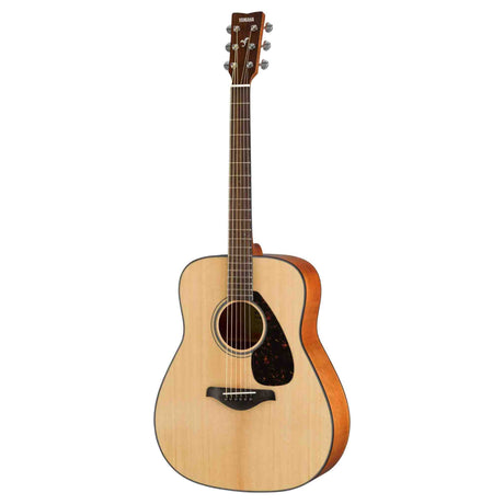 The image shows a Yamaha dreadnought acoustic guitar with a natural spruce top and darker wood back and sides. It features a round soundhole with a decorative rosette, a black teardrop pickguard, dark wood bridge, and chrome tuning pegs. The fretboard is dark with visible markers. This model likely belongs to Yamaha’s FG series, known for its quality sound, durability, and popularity among beginner to intermediate players.